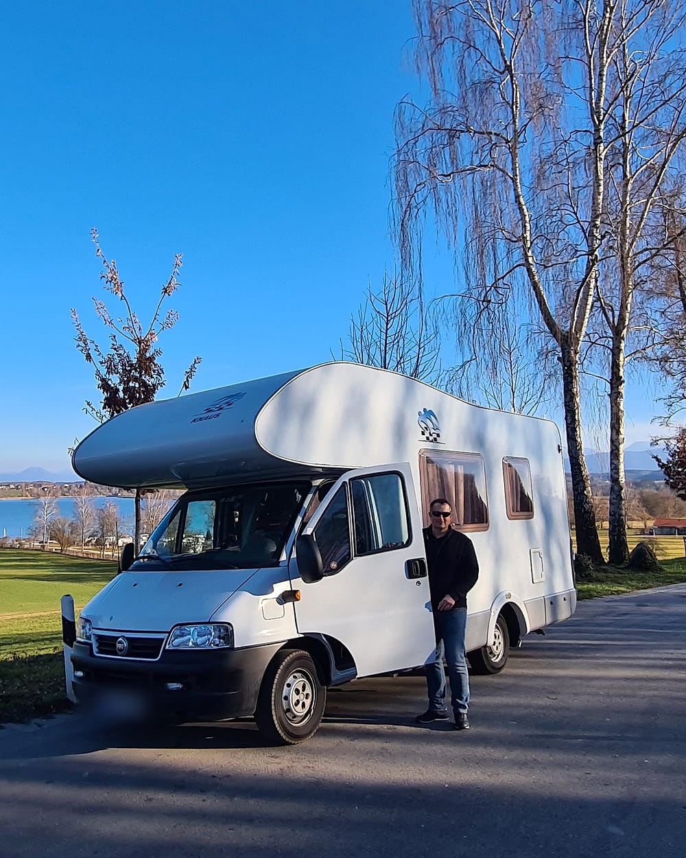Vor dem eigenen Wohnmobil an einem See